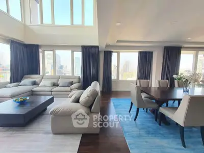 Luxurious open-plan living and dining area with city views, featuring elegant furniture and abundant natural light.