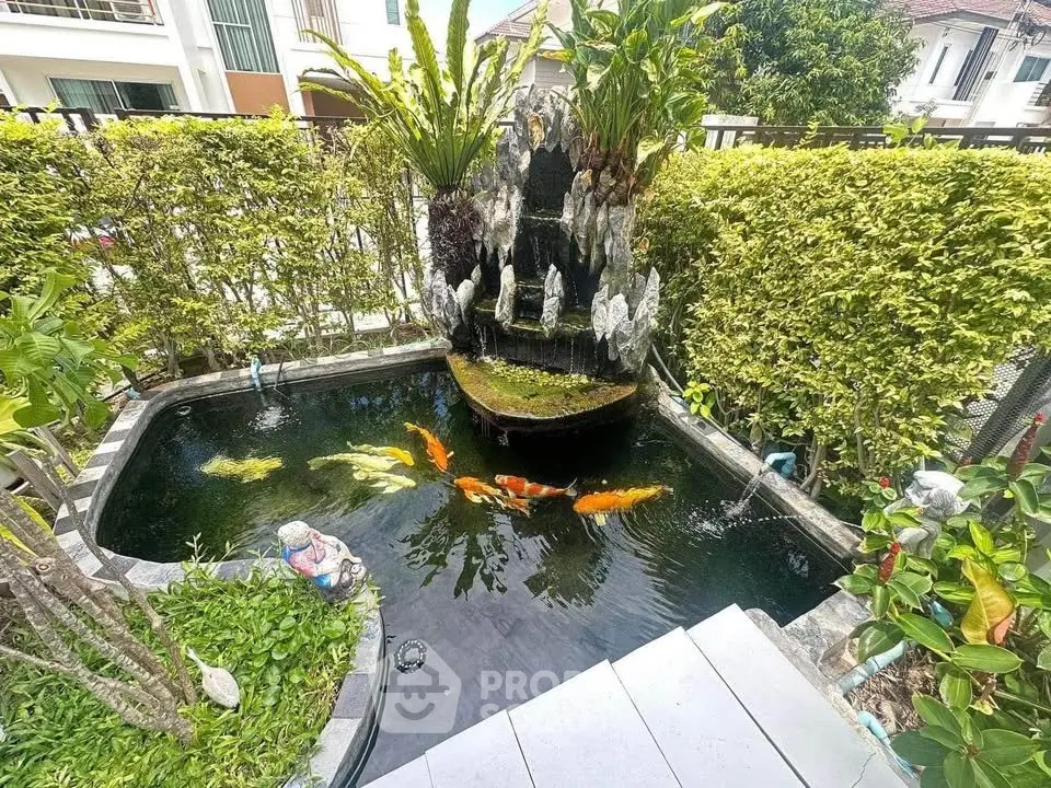 Charming garden with koi pond and lush greenery in a serene residential setting.