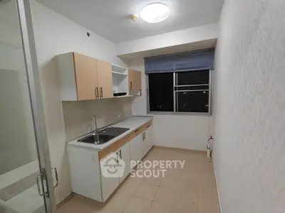 Compact kitchen with modern cabinetry and large window offering city views.
