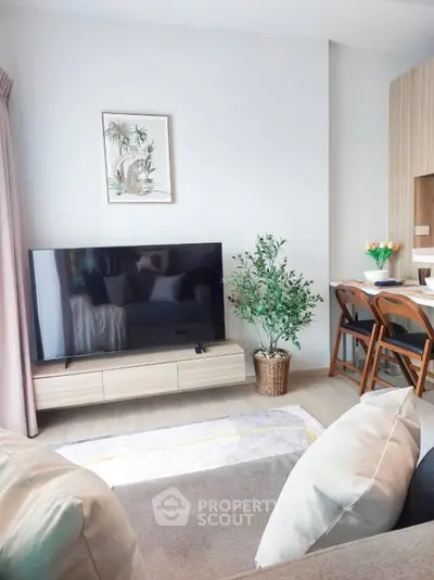 Modern living room with stylish decor and large TV, perfect for relaxation.