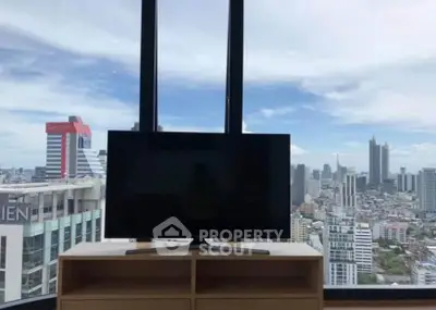 Stunning city view from modern apartment with large windows and sleek TV setup.