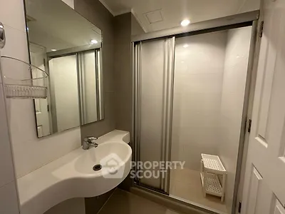 Modern bathroom with sleek shower and stylish sink in contemporary home.