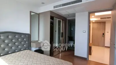 Modern bedroom with elegant headboard and en-suite bathroom in a stylish apartment.