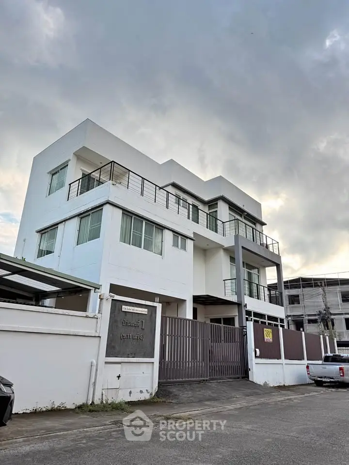 Modern white multi-story building with sleek design and large windows, perfect for urban living.