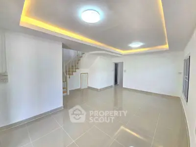 Spacious modern living room with elegant ceiling lights and glossy tiled flooring