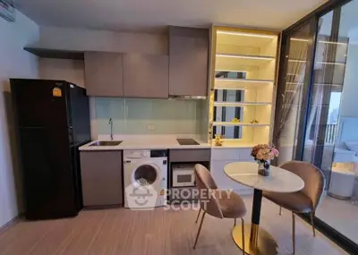 Modern kitchen with sleek appliances and cozy dining area in stylish apartment
