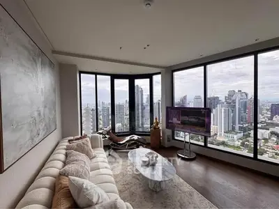 Luxurious living room with panoramic city views and modern decor in high-rise apartment.