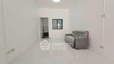 Spacious minimalist living room with sleek sofa and glossy white tiles