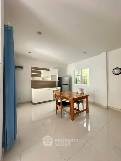 Modern kitchen with dining area featuring sleek cabinetry and natural light.