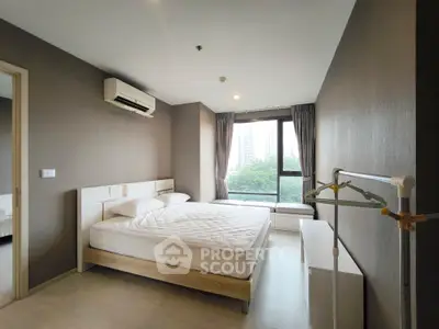 Modern bedroom with large window and city view, featuring a comfortable bed and air conditioning.