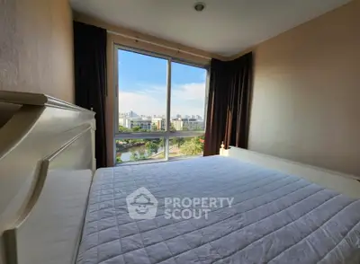 Spacious bedroom with large window offering stunning city view