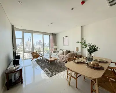 Spacious modern living room with city view, elegant decor, and natural light.