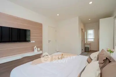 Modern bedroom with wall-mounted TV and cozy decor