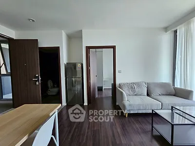Modern living room with sleek furniture and open layout, featuring a cozy sofa and stylish dining area.