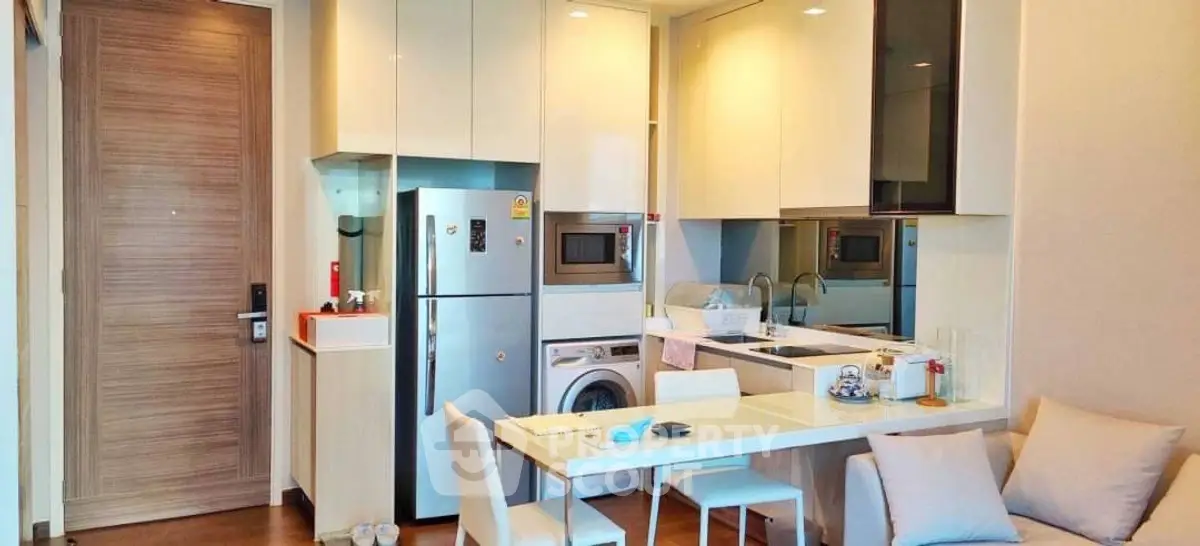 Modern kitchen and dining area with sleek appliances and cozy seating in a stylish apartment.