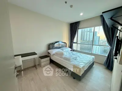 Modern bedroom with city view, featuring a cozy bed and sleek furnishings.