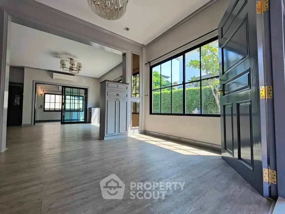 Spacious open-layout living room with large windows and elegant flooring