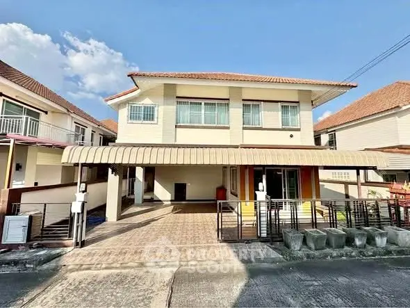 Charming two-story house with spacious driveway and tiled roof under clear blue sky.