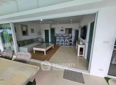 Spacious open-plan living room with modern kitchen and stylish decor, perfect for entertaining.