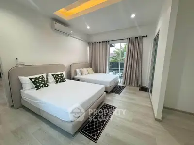 Spacious modern bedroom with two beds and balcony view