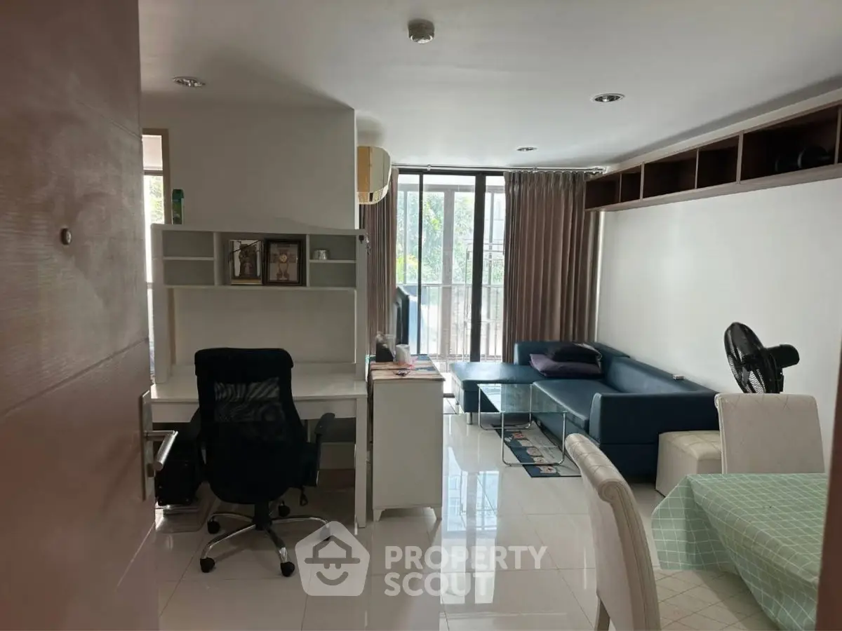 Modern living room with study area and large window for natural light.