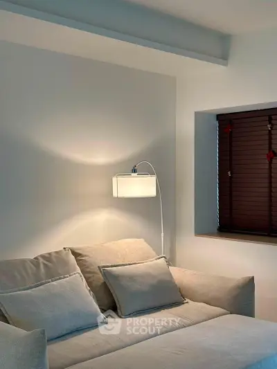 Cozy living room with modern sofa and elegant wall lamp, perfect for relaxation.