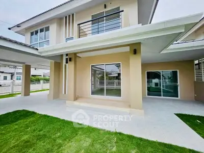 Modern two-story house with spacious patio and lush green lawn, perfect for family living.