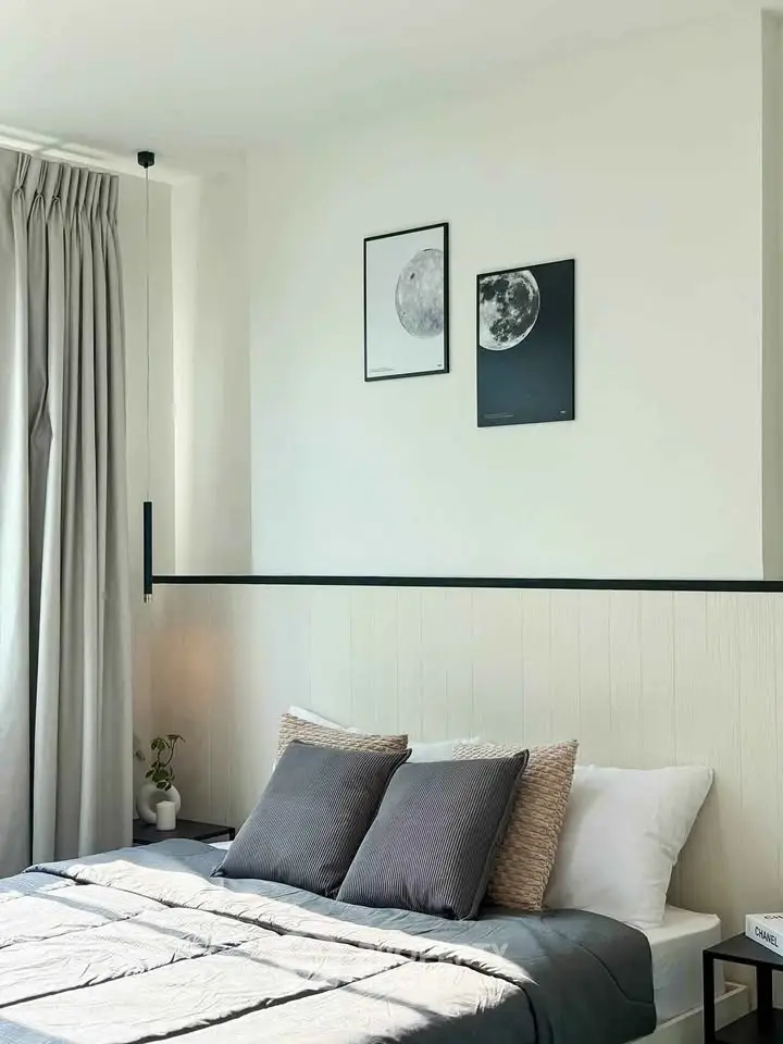 Modern bedroom with stylish decor and cozy bedding in a bright apartment.