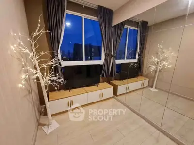 Modern living room with large mirror and decorative lighting, featuring a city view through the window.