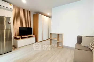 Modern living room with sleek design, featuring a TV, fridge, and stylish wooden accents.