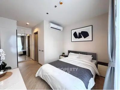 Modern bedroom with stylish decor and large mirror closet in a cozy apartment.