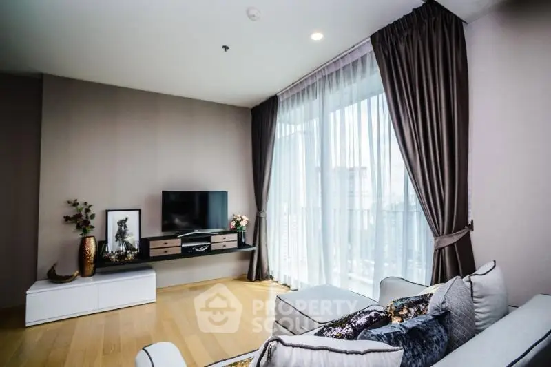 Modern living room with large windows and stylish decor in a high-rise apartment.