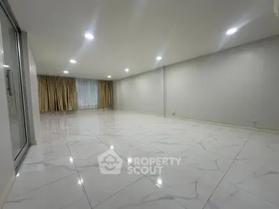 Spacious modern living room with marble flooring and recessed lighting