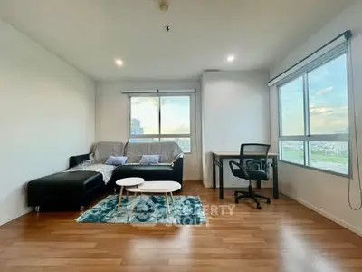Spacious living room with modern furniture and large windows offering a scenic view.