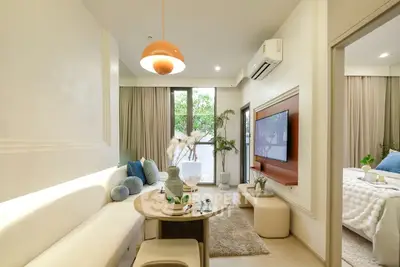 Modern living room with stylish decor and natural light, adjacent to a cozy bedroom.