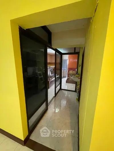 Spacious interior hallway leading to a cozy living area with natural light.
