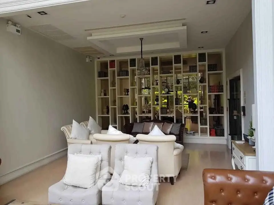 Luxurious living room with elegant seating and built-in bookshelf, perfect for relaxation and entertainment.