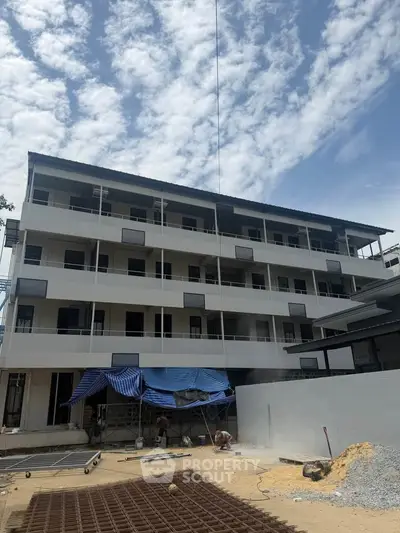 Modern multi-story building under construction with clear blue sky backdrop
