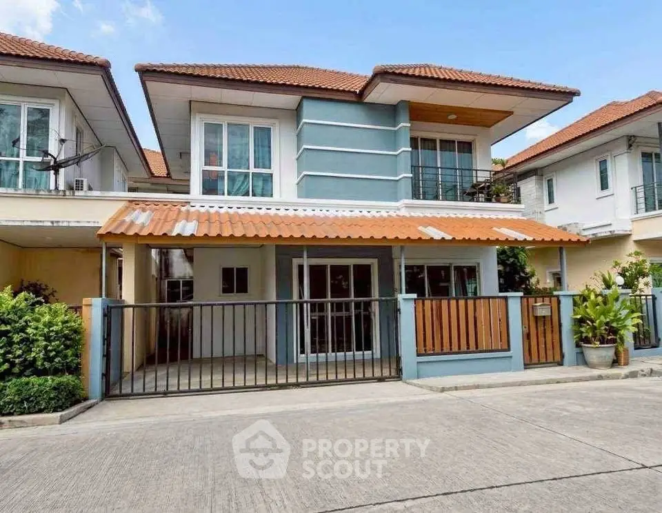Charming two-story house with a modern facade and gated entrance in a serene neighborhood.