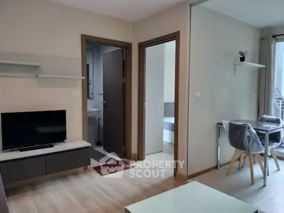 Modern living room with TV, dining area, and natural light