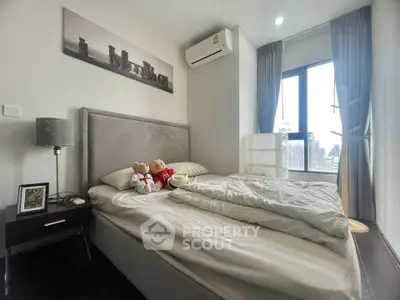 Cozy bedroom with large window and modern decor in a stylish apartment.