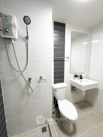 Modern bathroom with sleek fixtures and white tiles, featuring a shower and toilet.