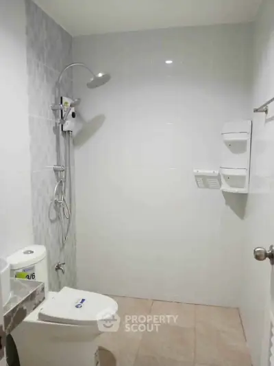 Modern bathroom with sleek shower and toilet in minimalist design.