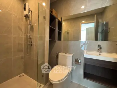 Modern bathroom with glass shower and sleek fixtures in a contemporary apartment.