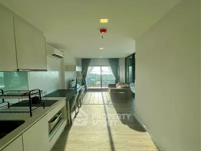 Modern open-layout kitchen with bright living area and scenic view.
