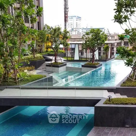Luxurious urban apartment complex with stunning outdoor pool and lush greenery.