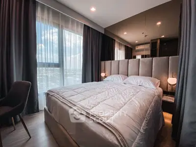 Luxurious bedroom with plush bedding and floor-to-ceiling windows offering stunning views.