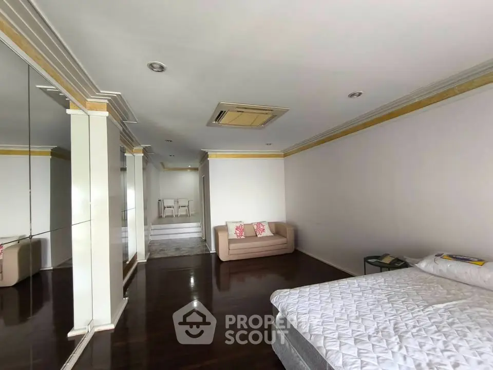 Spacious bedroom with elegant decor and cozy seating area