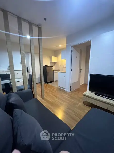 Modern open-plan living room with sleek kitchen and cozy seating area.