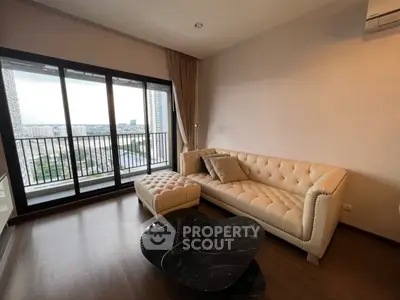 Elegant living room with plush sofa and city view balcony in modern apartment